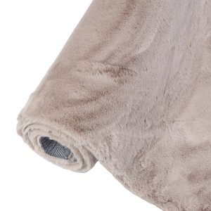 Zrolowany beżowy dywan z długim włosiem.