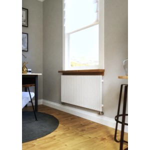 Biały grzejnik t.b.t. pod oknem w nowoczesnym pokoju.