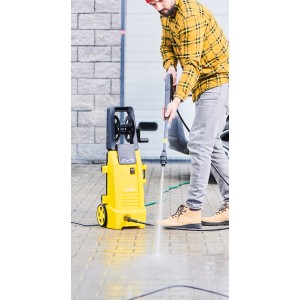 Żółta myjka ciśnieniowa t.b.t. w użyciu na utwardzonej powierzchni.