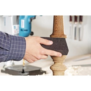 Gąbka ścierna LUX (średnia/gruba) w użyciu, szlifuje drewnianą nogę.
