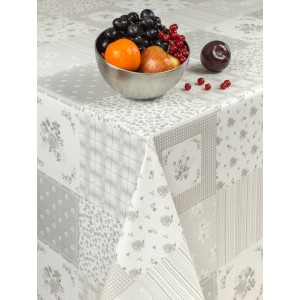 Obrus z wzorem patchworkowym w odcieniach szarości i bieli, ozdobiony misą z owocami.