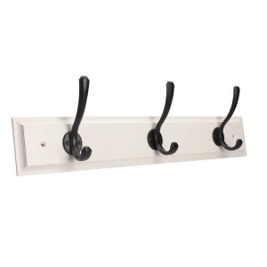 Wieszak z trzema czarnymi haczykami na białej drewnianej desce.