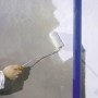 Ręka maluje ścianę wałkiem LUX Goldfadenwalze 12 cm. Wałek do ścian, sufitów i farb.
