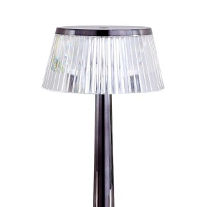 Lampa stołowa t.b.t. z przezroczystym kloszem i smukłą, ciemną podstawą.