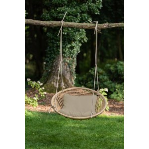 Wiszący fotel rattanowy t.b.t. z poduszką, zawieszony na drzewie.