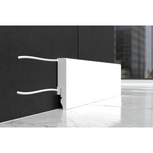 Biała listwa przypodłogowa t.b.t. z kanałem kablowym na ciemnej ścianie.