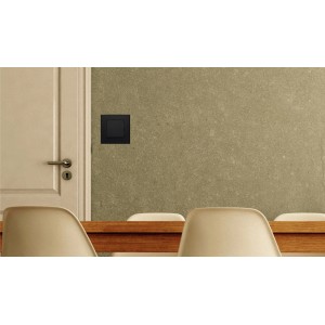 Czarny włącznik/przycisk t.b.t. zamontowany na ścianie.