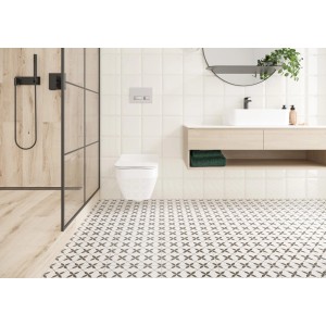 Łazienka z płytkami podłogowymi t.b.t. w kolorze białym i szarym z kwiatowym wzorem.