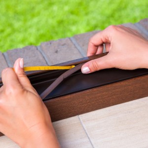 Montaż brązowej uszczelki okiennej (t.b.t.) do ramy okiennej.