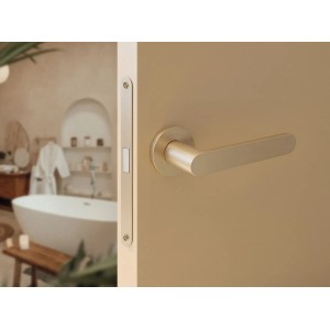 Nowoczesna, złota klamka do drzwi na drzwiach. Okucia do drzwi wewnętrznych.