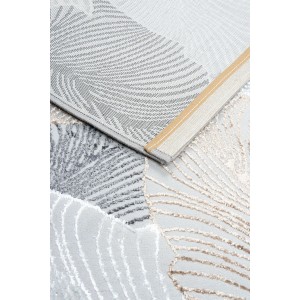 Zbliżenie nowoczesnego, jasnego dywanu z krótkim włosiem o abstrakcyjnym wzorze.