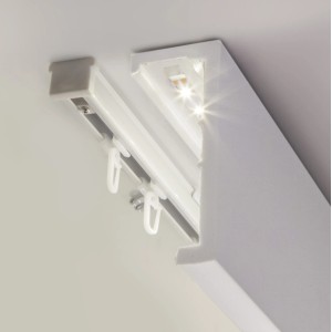 Zbliżenie białego karnisza sufitowego t.b.t. z oświetleniem LED i haczykami do zasłon.