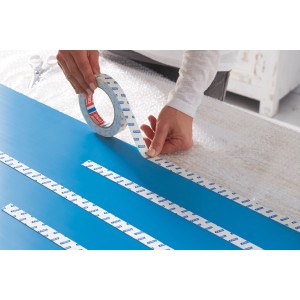 Nakładanie dwustronnej taśmy klejącej na niebieską powierzchnię.