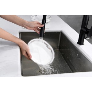 Bateria kuchenna: Ręce myją talerz pod bieżącą wodą w zlewozmywaku ze stali nierdzewnej.