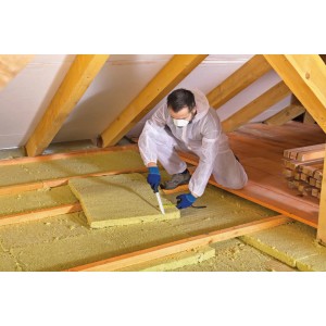 Rzemieślnik tnie izolację nożem LUX (280 mm) na poddaszu.