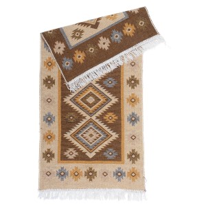 Dywan z krótkim włosiem t.b.t. z etnicznym wzorem w kolorze brązowym, beżowym i białym.