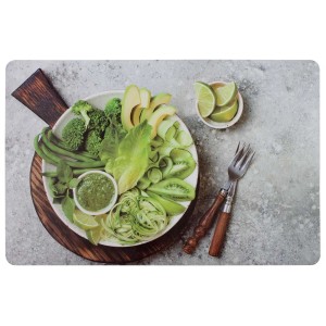 Podkładka z zielonymi warzywami i limonkami na szarym tle.