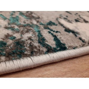 Zbliżenie dywanu z krótkim włosiem, abstrakcyjny wzór w szarości i turkusie.