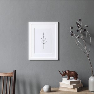 Szara farba do ścian t.b.t. z białym obrazem rośliny w ramce. Dekoracyjny wystrój ściany.