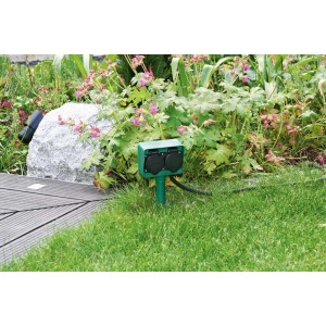 Zielone gniazdo ogrodowe t.b.t. z dwoma wyjściami w trawniku.