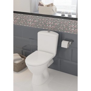 Białe kompaktowe WC t.b.t. na tle szarych płytek w łazience.