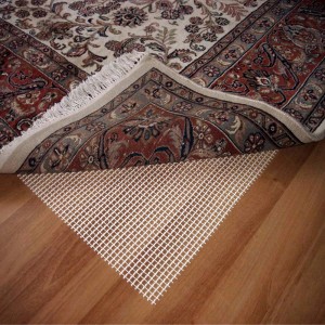 Dywan z matą antypoślizgową na drewnianej podłodze. Maty pod dywany zapobiegają ślizganiu.