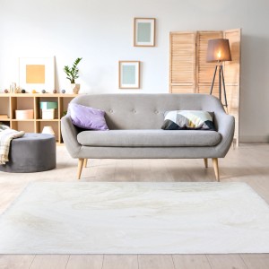 Biały, marmurkowy dywan z długim włosiem t.b.t. w salonie.