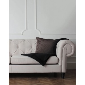 Dekoracyjna, brązowa, pikowana poduszka na sofie. Przytulne Poduszki do Twojego domu.