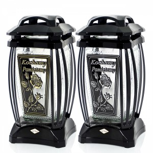 Dwa czarne znicze z różą i napisem 'Kochamy Pamiętamy'.