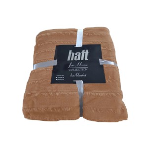 Związany, ochrowy koc t.b.t. z frędzlami.