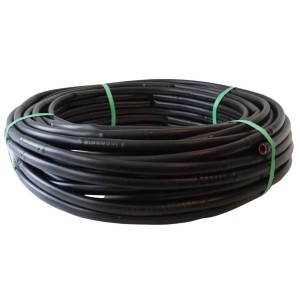 Czarna rura t.b.t. do nawadniania podziemnego, zwinięta i zabezpieczona zieloną taśmą.