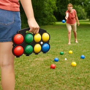 Zestaw do gry w bule z kolorowymi kulami i kulką celowniczą w nosidełku, w tle kobieta grająca w bule.