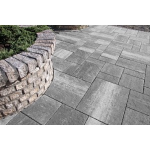 Szara kostka brukowa t.b.t. na tarasie z kamiennym murem.