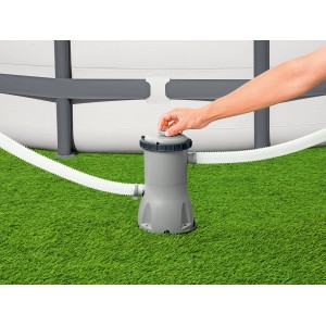 Pompa filtrująca Bestway 3.028 l/h obok basenu na trawie, ręka na zamknięciu.