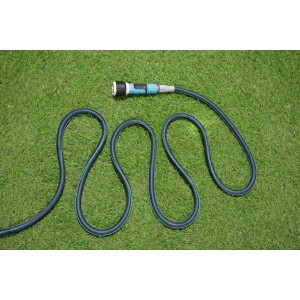 Ciemnozielony wąż ogrodowy t.b.t. na trawniku. Łatwe nawadnianie.