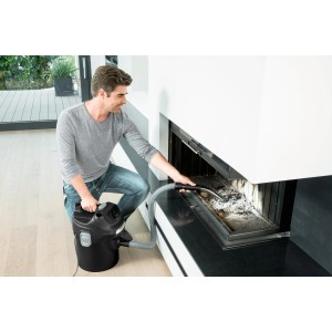 Mężczyzna czyści kominek odkurzaczem do popiołu Kärcher AD 2. Akcesoria kominkowe.