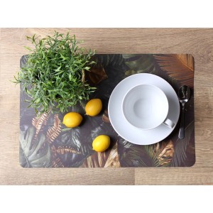 Podkładka na stół z motywem dżungli, talerz, filiżanka, łyżka, cytryna i roślina na drewnianym stole.