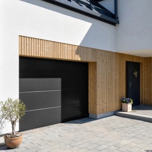 Nowoczesna, czarna brama garażowa t.b.t. z poziomymi liniami w fasadzie domu.