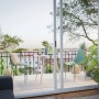 Balkon z dwoma zielonymi krzesłami ogrodowymi i stołem. Kategoria: Krzesła ogrodowe.