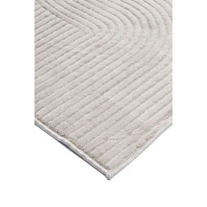 Zbliżenie beżowego dywanu z krótkim włosiem t.b.t. ze wzorem falistych linii.