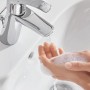 Błyszcząca bateria umywalkowa Grohe Start S-Size z zestawem odpływowym push-open w białej umywalce.
