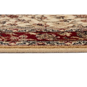 Zbliżenie dywanu z krótkim włosiem o klasycznym wzorze w kolorze beżowym i czerwonym.