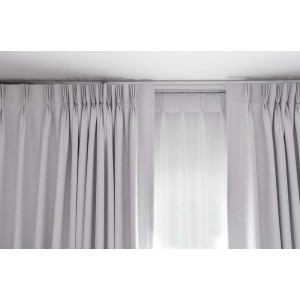 Szare zasłony z taśmą marszczącą zawieszone na karniszu.