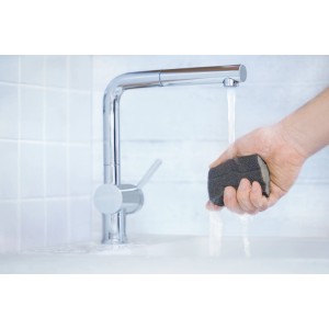 Ręka szlifuje materiałem ściernym pod bieżącą wodą.