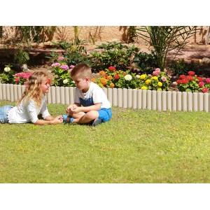 Dzieci siedzą przed beżowym obrzeżem t.b.t. jako obramowanie ogrodu.