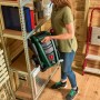 Osoba przechowuje kompaktową myjkę ciśnieniową Bosch Universal Aquatak 125 na półce. Łatwe przechowywanie.