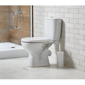 Białe, kompaktowe WC t.b.t. ze spłuczką i szczotką toaletową w łazience.