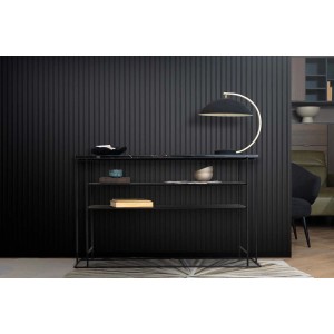 Czarne panele ścienne t.b.t. za regałem z dekoracjami i lampą.