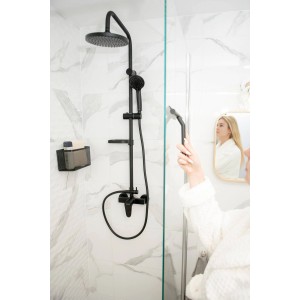 Czarna kolumna prysznicowa t.b.t. z deszczownicą i słuchawką na tle białej marmurowej ściany.