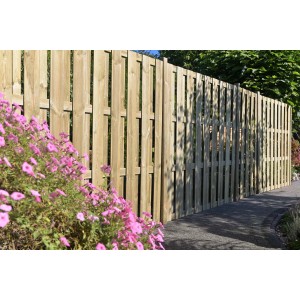 Element ogrodzenia drewnianego, naturalny, z różowymi kwiatami na pierwszym planie.